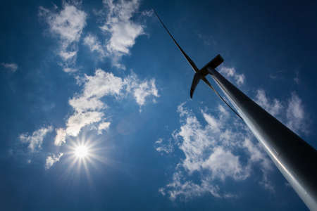 Wind Turbine with path on green field with blue skyの写真素材