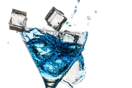 Ice cubes in broken glass with blue martini on white backgroundの写真素材