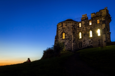 Silhouette of a person sitting near to the Gothic House in Edinburghの写真素材