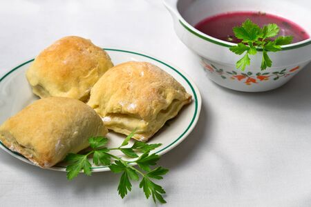 Homemade borsch with small pie on white tableclothの写真素材