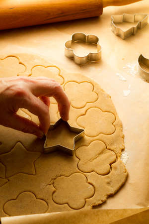 Cutting of Christmas cookies on baking paper