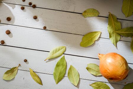 Bay leaf and onion on old wooden tableの写真素材