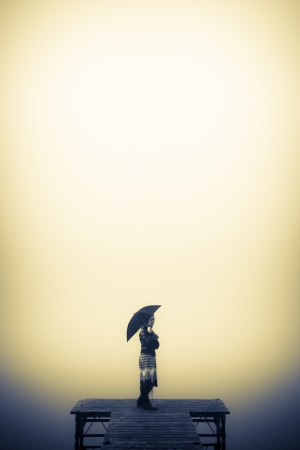 Lonely woman looks to the misty lakeの写真素材