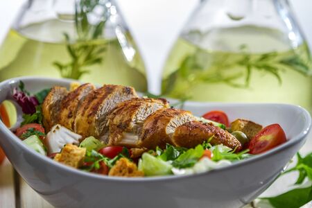 Chicken salad on a background bottles of olive oilの写真素材
