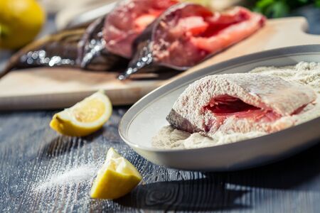 Close-up of fresh fish dipped in flour and seasoned with lemonの写真素材
