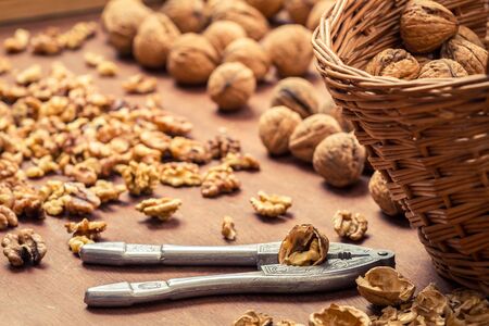 Closeup of cracking walnuts on wicker basketの写真素材