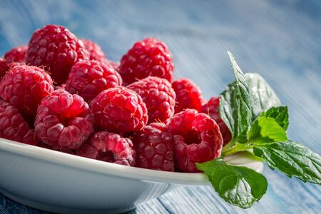 Closeup of fresh raspberries with green leaf
