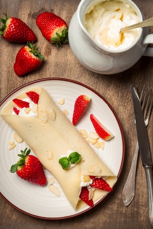 Pancakes with strawberries served on breakfastの写真素材