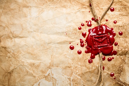 Envelope symbol imprinted in red sealing wax on old paper