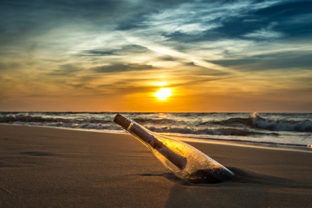 Ancient message in a bottle on a sea shoreの写真素材