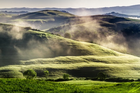 Misty hills in Tuscany at sunriseの写真素材