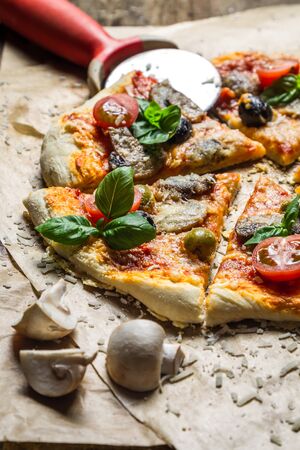 Cutting homemade pizza on old tableの写真素材