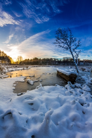 Old boat on the lake covered with snow in winterの写真素材