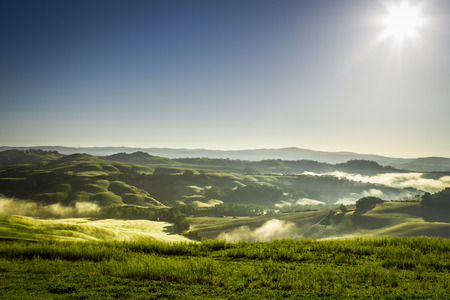 Misty hills in Tuscany at sunrise