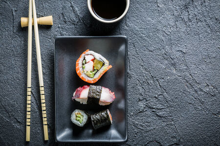 Sushi served on a black ceramic with soy sauceの写真素材