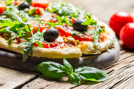 Freshly baked pizza with basil and tomatoesの写真素材
