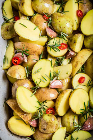 Prepared baking potatoes with rosemary and garlicの写真素材