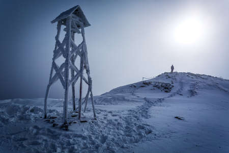 Lone man on the top of the mountain in winterの写真素材