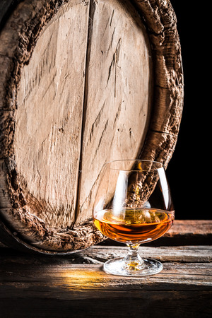 Wooden oak barrel and a glass of cognacの写真素材