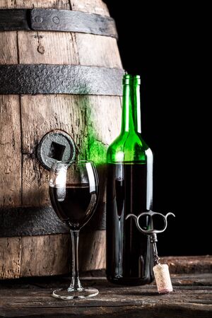Glass of wine and bottle in the old cellarの写真素材