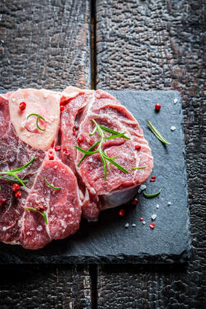 Meat with fresh herbs on a stone plateの写真素材