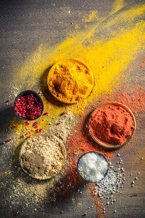 Vivid herbs and spices on old tableの写真素材