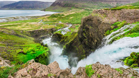 Waterfall flowing into a valley in Icelandの写真素材