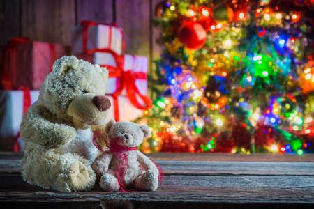 Teddy bear and Christmas tree with presents on background
