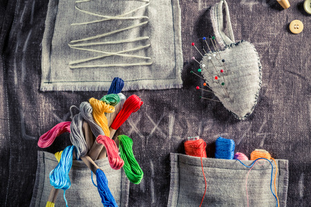 Handmade sewing cloth with scissors, needles and threads in tailor workshopの写真素材