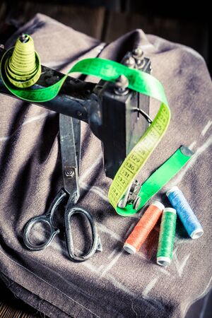 Old sewing machine with tailor tape, needle and threadsの写真素材