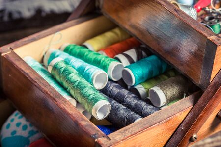 Vintage tailor's wooden box with threads, needles and buttons