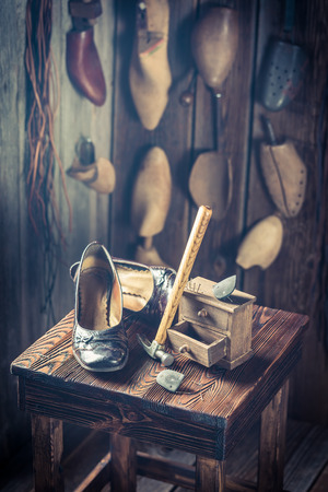 Aged shoemaker workplace with tools, shoes and leatherの写真素材
