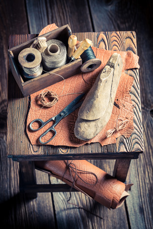 Small cobbler workshop with tools, shoes and leatherの写真素材