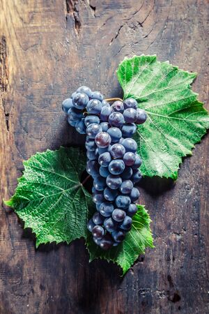 Red grapes with leaves on wooden boardの写真素材