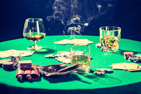 Old gambling table with whiskey, cigar and cardsの写真素材