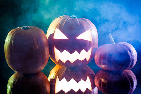 Halloween pumpkin head with blue and green smokeの写真素材