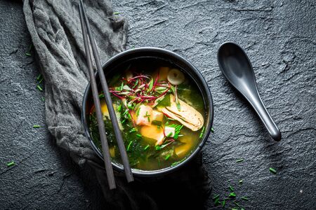Hot miso soup with salmon in black bowlの写真素材