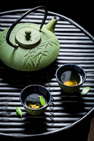 Fresh herbal tea with teapot on black tableの写真素材