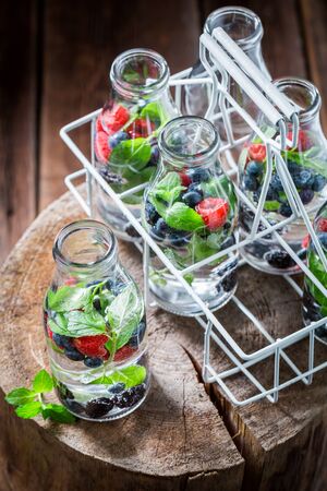 Fruity water in bottle with raspberries, blueberries and blackberriesの写真素材