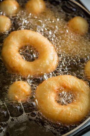 Frying tasty and homemade donuts on fresh oilの写真素材