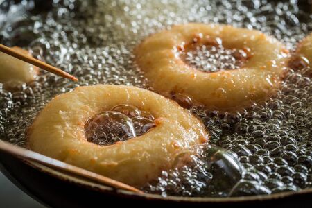 Frying sweet and tasty donuts on hot oilの写真素材