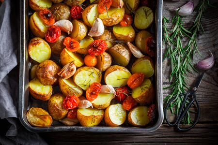Crispy roasted potato with garlic, tomato and rosemaryの写真素材