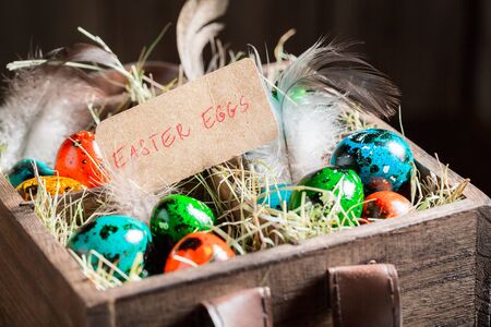 Eggs for Easter with hay and feathers in wooden boxの写真素材