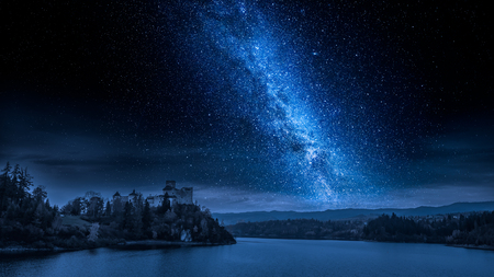 Beautiful castle by the lake at night with milky wayの写真素材