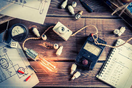 Table with electrical diagrams, a light bulb and booksの写真素材