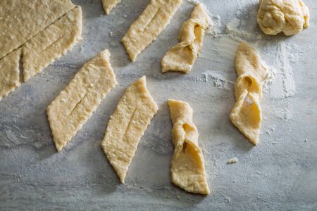 Cutting homemade donuts from fresh dough on grey tableの写真素材