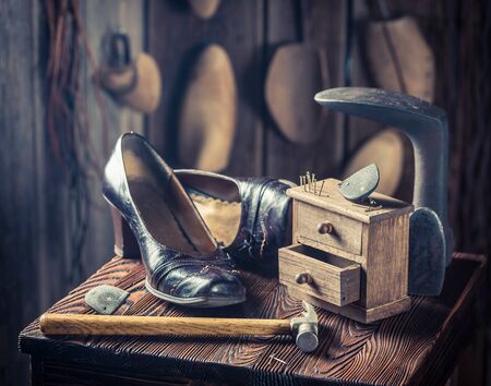 Old cobbler workshop with shoes, hammer and nailsの写真素材
