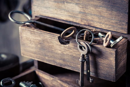 Wooden box with old keys in old locksmiths workshopの写真素材