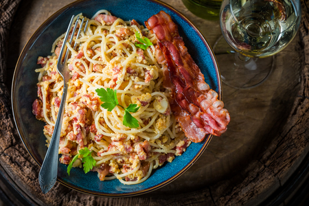 Delicious spaghetti Carborana served with white wineの写真素材