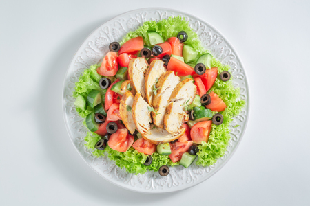 Fresh Caesar salad with chicken, olives and tomatoesの写真素材